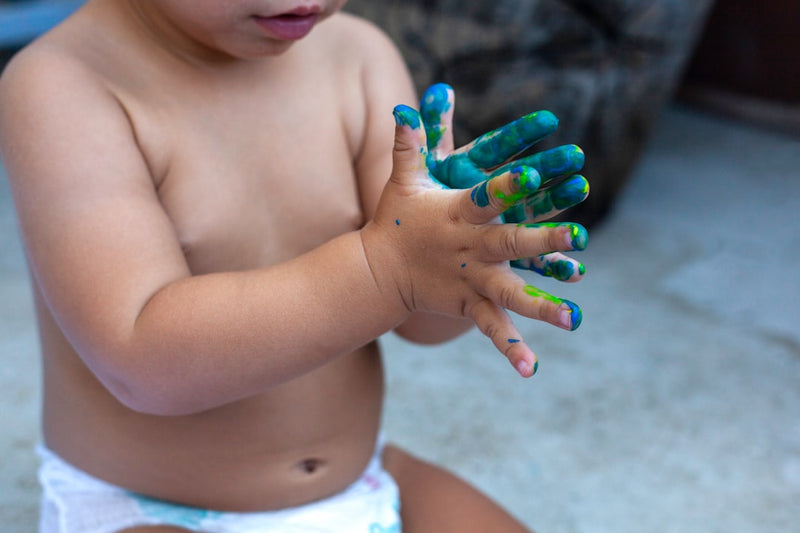 Kinderhände erkunden taktile Materialien — Schlamm, Sand und Naturstoffe